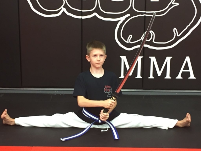 Iron Fist Tae Kwon Do student posing with a katana